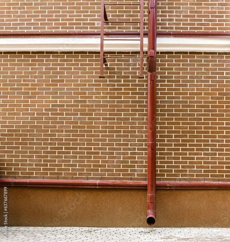 Фотография red brick wall of renovated old industrial building with newly installed drainpi