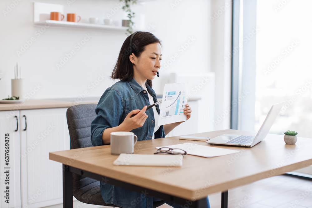 Woman analyzing graph on video conference via laptop at home Woman analyzing graph on video conference via laptop at home