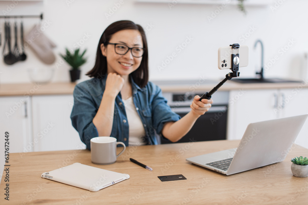 Asian woman recording online courses on smartphone indoors Asian woman recording online courses on smartphone indoors