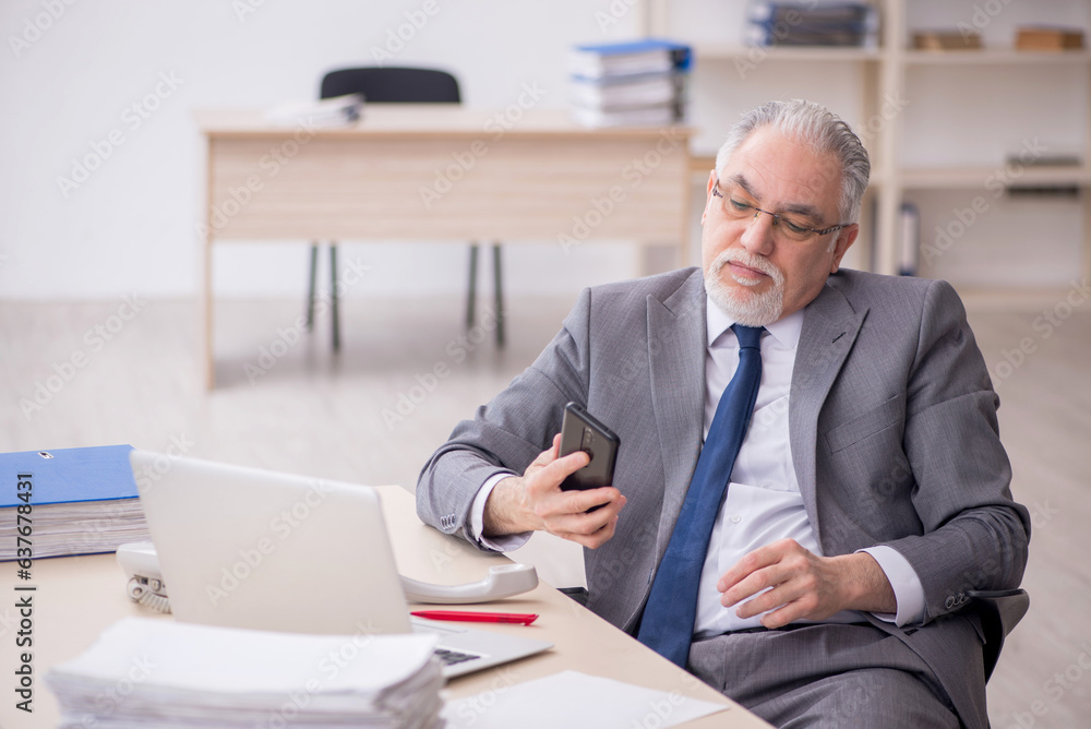 Old male employee working in the office Old male employee working in the office
