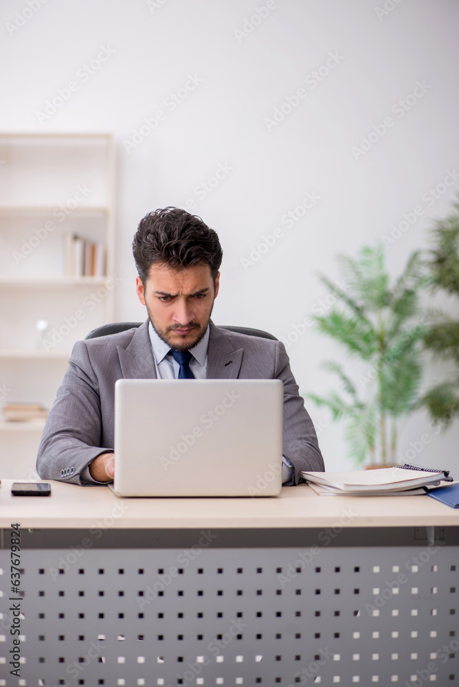 Young male employee and too much work in the office Young male employee and too much work in the office