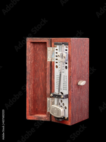 An old fashioned metronome ,made from wood box, black background, Selective focus photo