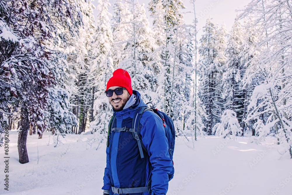 Man wearing red beanie smiling outdoors in the winter,