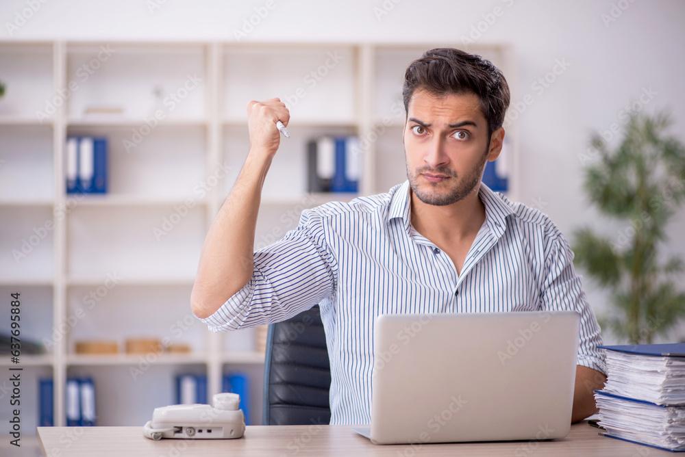 Young male employee working in the office Young male employee working in the office