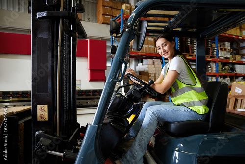 portrait female worker driving a forklift in the warehouse storage
