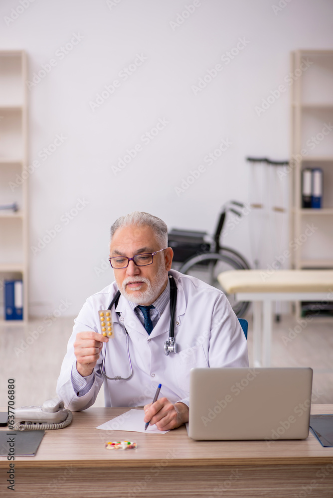 Old male doctor working in the clinic Old male doctor working in the clinic