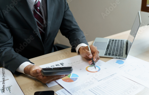 Businessman Accountant analyzing investment charts Invoice and pressing calculator buttons over documents. Accounting Bookkeeper Clerk Bank Advisor And Auditor Concept.