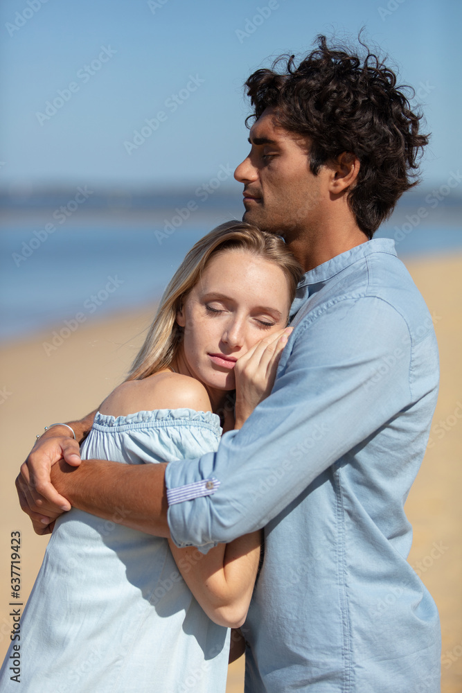 attractive couple cuddling at the beach attractive couple cuddling at the beach