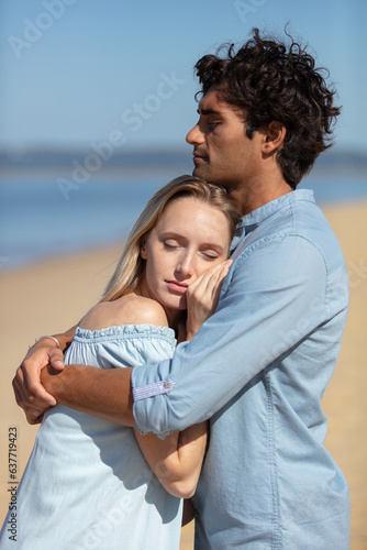 attractive couple cuddling at the beach