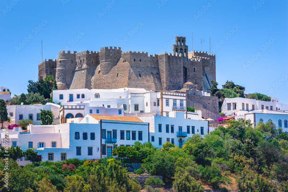 The three windmills of Chora and iconic Monastery of Saint John the Theologian in chora of Patmos island, Dodecanese, Greece - obrazy, fototapety, plakaty 
