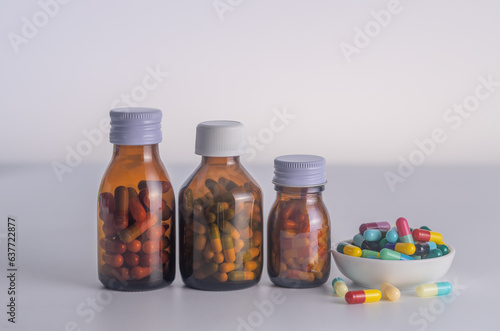  3 bottles of medicine without labels  with medicine cup on a white background