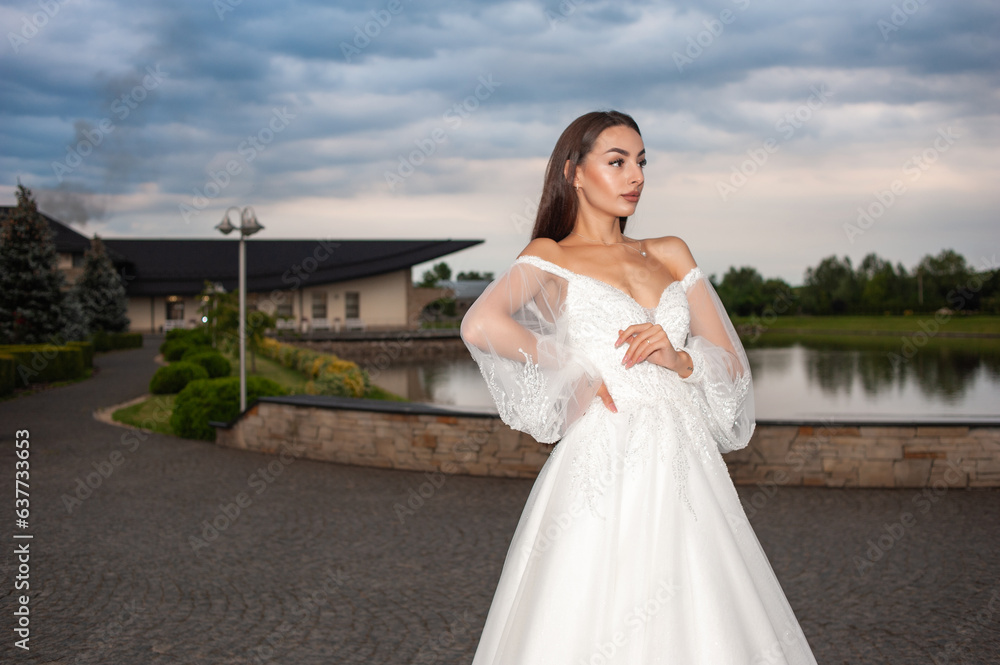 Beautiful bride in wedding dress posing on sunset near lake Beautiful bride in wedding dress posing on sunset near lake