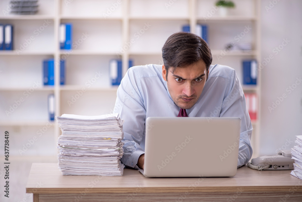 Fototapeta premium Young male employee and too much work in the office