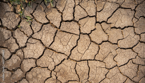 Cracked ground background in the top view for graphic design or wallpaper. Natural texture with the concept of drought and death. Empty space with abstract pattern in vintage style.