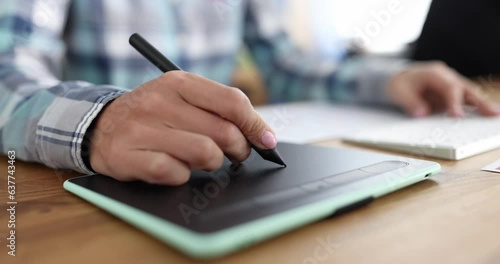 Closeup of graphics tablet and a woman hand. Home freelancer and designer photo