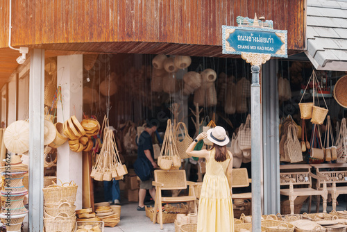 Canvas Print Young asian woman traveler in dress with hat traveling to wicker shop on Chang Moi Kao Road, Tourist visit at the old city in Chang Mai, Thailand