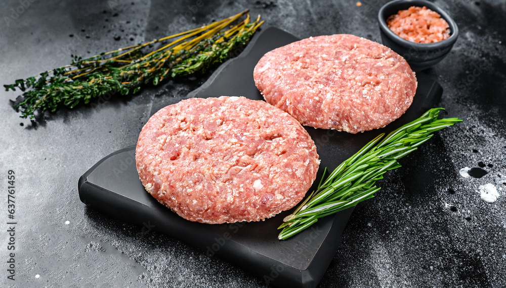 Raw chicken patty, ground meat cutlets on a chopping Board. Organic mince. Black background. Top view Raw chicken patty, ground meat cutlets on a chopping Board. Organic mince. Black background. Top view