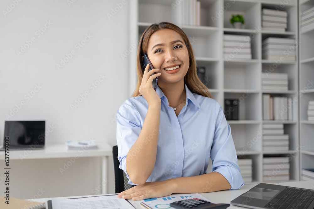Asian woman talking on the phone in startup company office, businesswoman senior executive company executive talking on the phone in office room, business negotiation. Business administration concept. Asian woman talking on the phone in startup company office, businesswoman senior executive company executive talking on the phone in office room, business negotiation. Business administration concept.