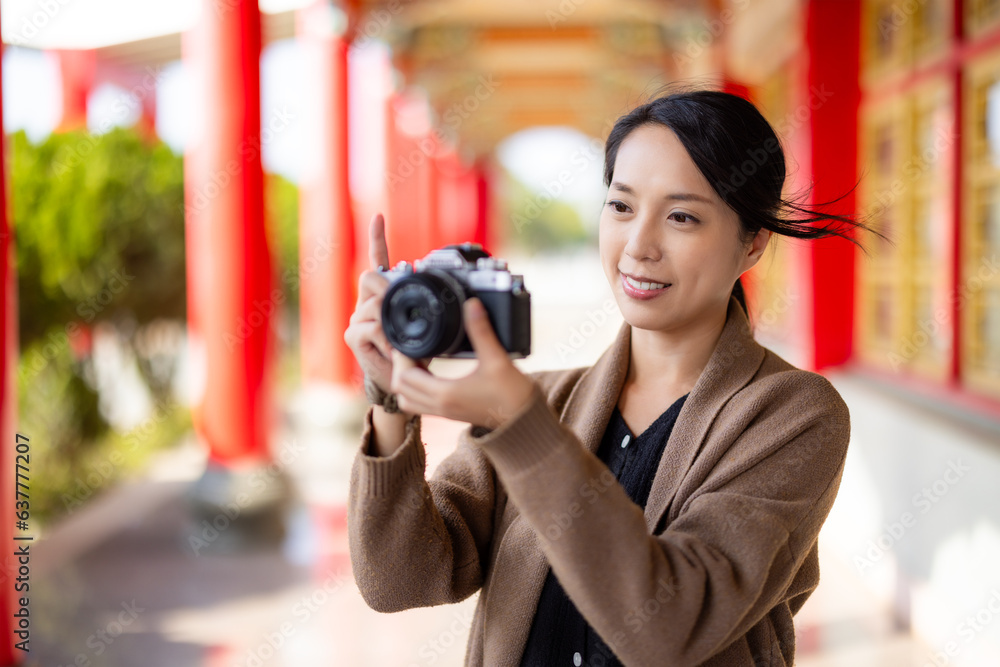 Woman use of digital camera to take photo in Chinese temple