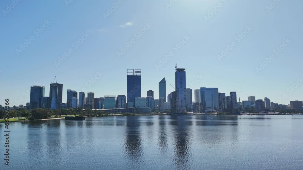 Drone flying along swan river in Perth, Western Australia on sunny day with silhouette of city skyline in the background Drone flying along swan river in Perth, Western Australia on sunny day with silhouette of city skyline in the background