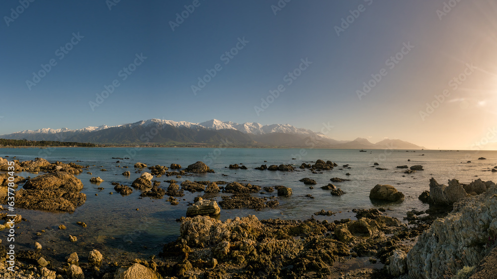 Coastal sunrise at Kaikoura with the snow covered mountains in the background Coastal sunrise at Kaikoura with the snow covered mountains in the background