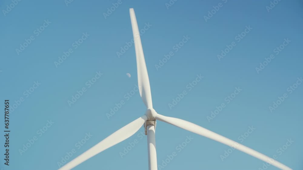 Wind turbine in operation for the production of electrical energy and the moon in the background. Close up. Wind turbine in operation for the production of electrical energy and the moon in the background. Close up.