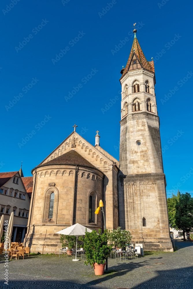 Die Johanniskirche, ein Wahrzeichen von Schwäbisch Gmünd auf dem Marktplatz in der Altstadt mit leerem Straßencafe bei schönem Sommerwetter