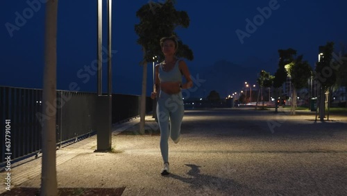 Woman running at nighttime. Young woman run sunrise seaside. Concept of health and lifestyle.