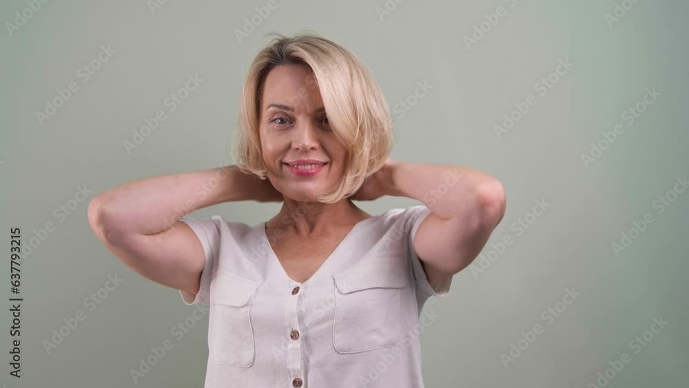 Beautiful woman looking at camera and smiling on grey background Beautiful woman looking at camera and smiling on grey background