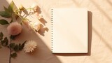 A flat lay workplace template with blank paper notebook pen and floral shadows on a beige background. Mockup image