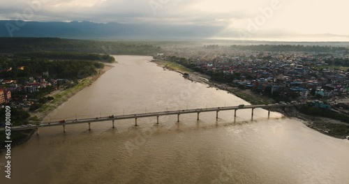 Landscape of Narayani River Bridge at Chitwan Nepal. Drone Shot. Traffic, Vehicles running, Urban City, Flowing River, Golden Sky, Monsoon Season. Travel, Transportation, River, Nature, Scenic Video. photo
