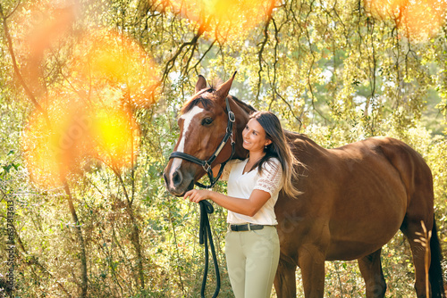 Carefree horsewoman embracing brown horse in forest