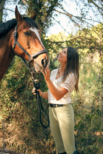 Delighted woman stroking horse in woods