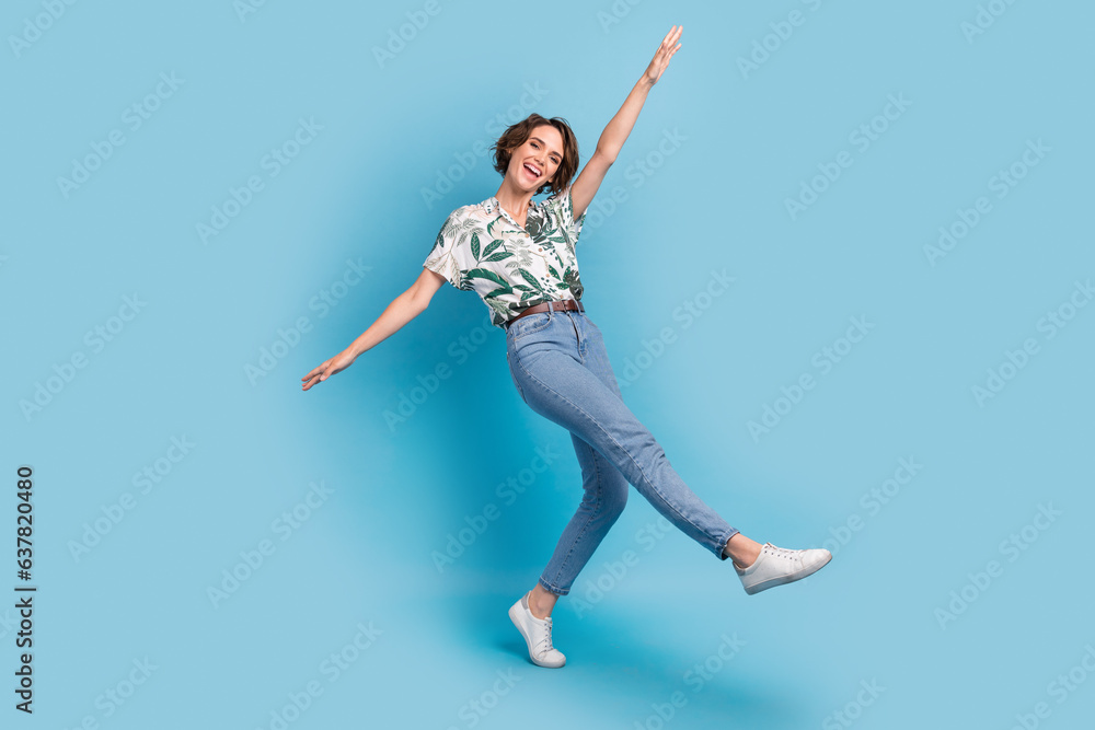 Full length photo of charming carefree lady wear print shirt walking having fun isolated blue color background Full length photo of charming carefree lady wear print shirt walking having fun isolated blue color background
