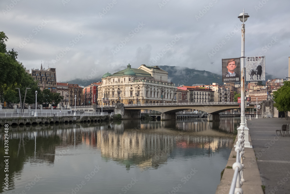 Fototapeta premium Exterior view at the Nervión river and Areatzako zubia bridge, Arriaga square, an iconic plaza on Casco Viejo, Arriaga Theatre, Bilbao downtown city, Spain