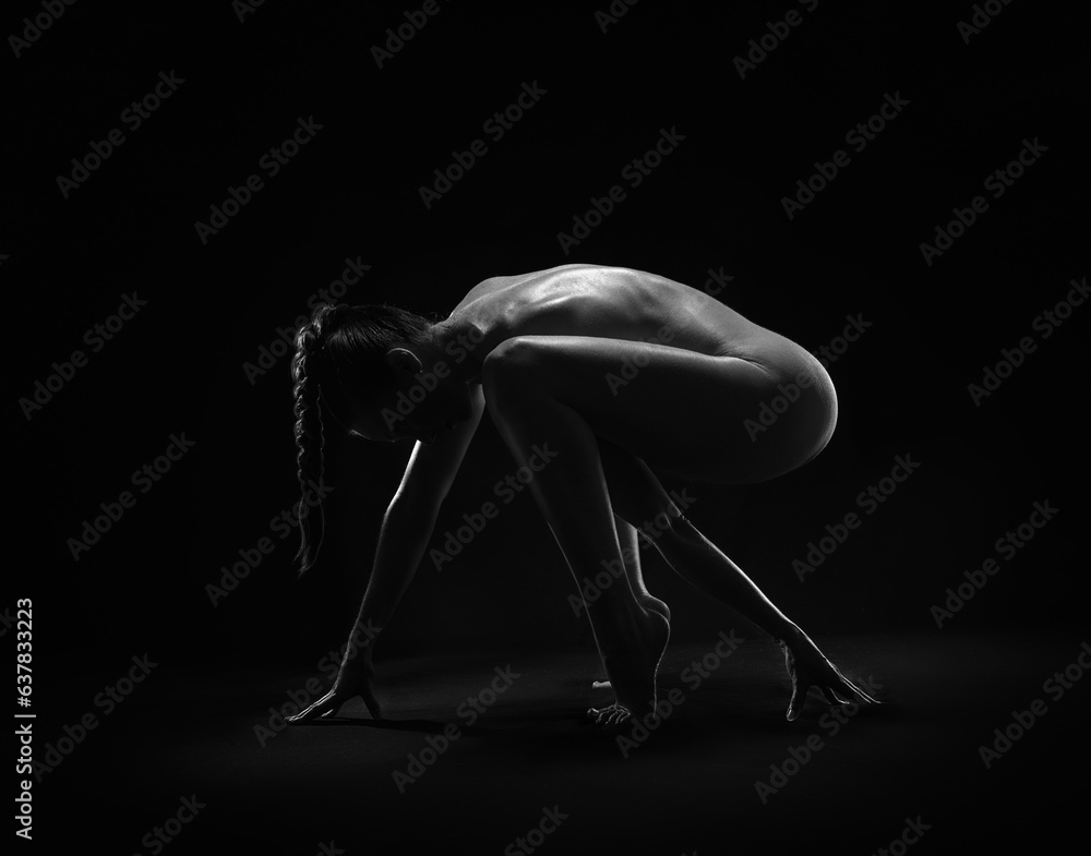 Beautiful sexy fitness girl with a great figure flexing her perfect body in a yoga pose at the studio. Black and white photo - obrazy, fototapety, plakaty 