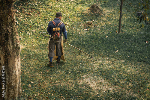 landscape maintenance gardener mowing grass in the gentle morning hues