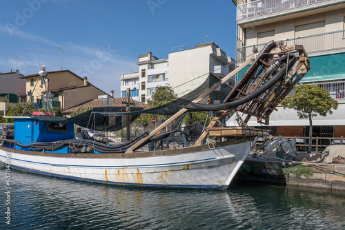 Vongolara fishing boat with clam-rake at embankment of Grado Old harbor, Friuli, Italy photo