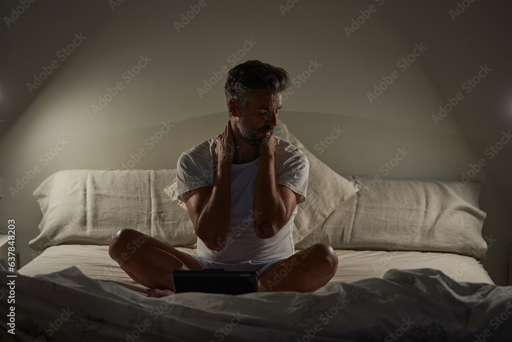 Exhausted mature ethnic man resting after working on tablet in b Exhausted mature ethnic man resting after working on tablet in b