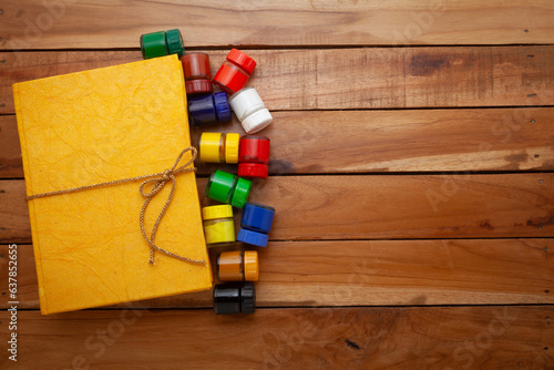 Beautiful Yellow Colour handmade paper Diary, with some fabric colors. Wooden background. Top view.