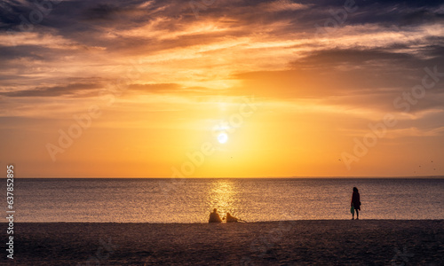 Personas contemplando el atardecer en la playa de Almería © Carmen