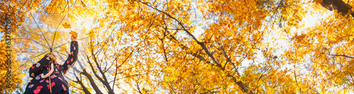 Autumn child in the park with yellow leaves. Selective focus.