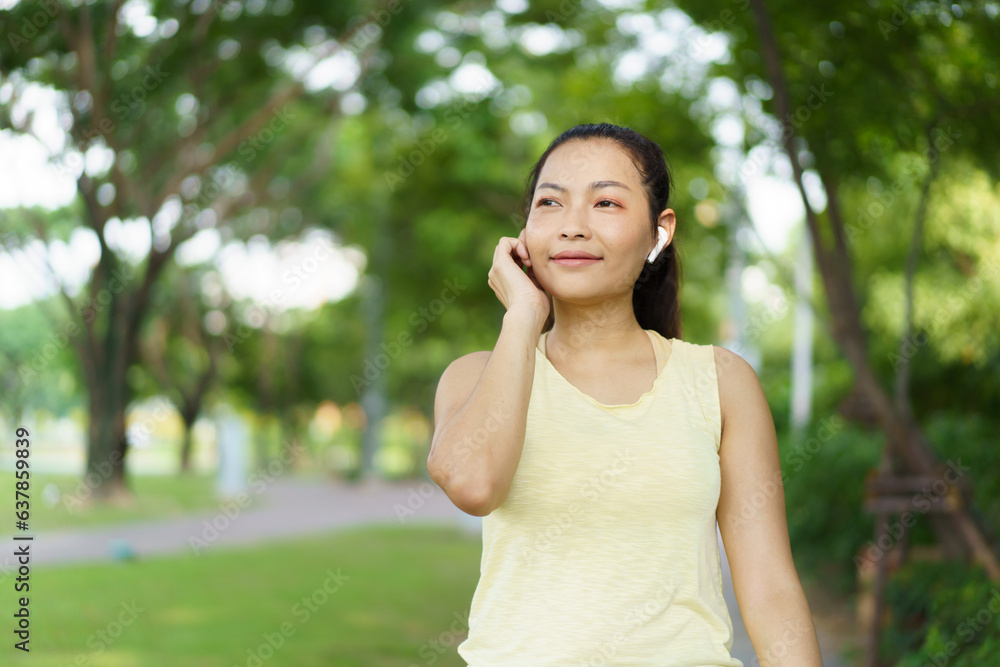 Beautiful smart and good looking Asian adult woman checking on a smartwatch or fitness tracker while practicing running - jogging at the park. Beautiful smart and good looking Asian adult woman checking on a smartwatch or fitness tracker while practicing running - jogging at the park.