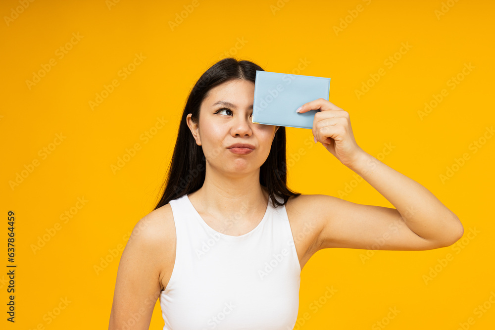 A girl of Asian appearance with a passport in her hands. A girl of Asian appearance with a passport in her hands.