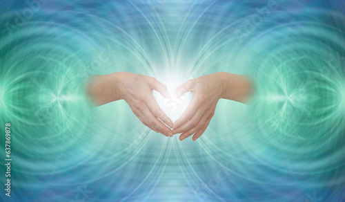 Sending out heart-centred Scalar Healing  - Female hands making a heart shape against symmetrical  jade green blue energy resonance  background with space for text
