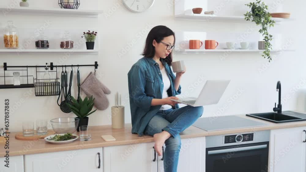 Lady with tea cup teleworking from home using laptop Lady with tea cup teleworking from home using laptop