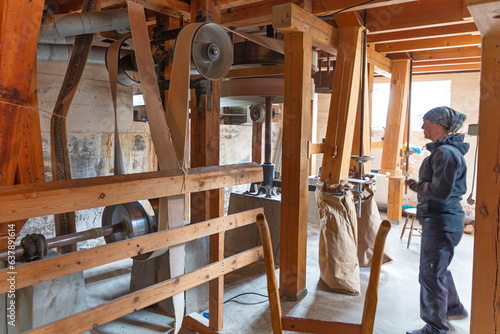 Woman in flour mill checking working machinery