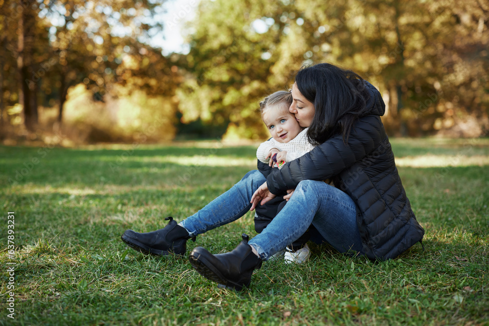 Mother and daughter sitting and hugging in autumn park Mother and daughter sitting and hugging in autumn park