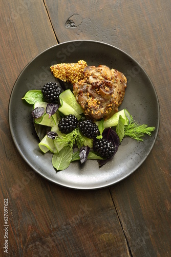Roasted turkey thigh with green salad and blackberries, served with french mustard, vertical,
view from above