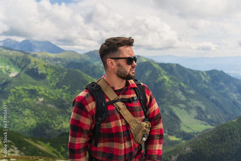 Portrait of a man with a beard in sunglasses and a shirt, a traveler in the Tatra mountains in summer. Portrait of a man with a beard in sunglasses and a shirt, a traveler in the Tatra mountains in summer.
